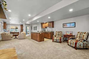 Carpeted living room with a textured ceiling and sink