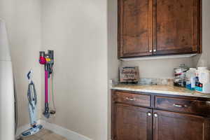 Interior space featuring light stone countertops, dark brown cabinets, and light tile patterned floors