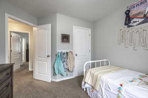 Bedroom with a textured ceiling and dark colored carpet