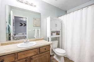 Bathroom featuring tile patterned floors, vanity, toilet, and a textured ceiling