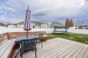 Wooden deck with a trampoline and a yard