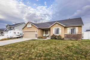 Ranch-style house with a front yard and a garage