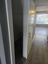 Corridor featuring dark wood-type flooring and a textured ceiling