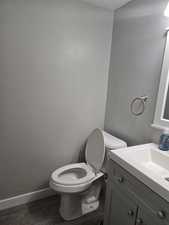 Bathroom featuring hardwood / wood-style floors, vanity, and toilet