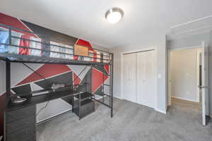 Bedroom featuring carpet flooring and a closet