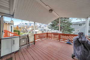 Wooden deck with a mountain view and grilling area