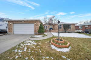 Single story home featuring a garage and a front yard