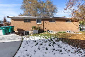 Snow covered back of property with central air condition unit