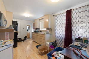 Kitchen featuring light wood-type flooring and cream cabinets