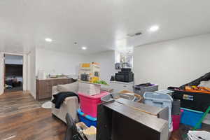 Interior space with a textured ceiling, dark hardwood / wood-style flooring, and sink