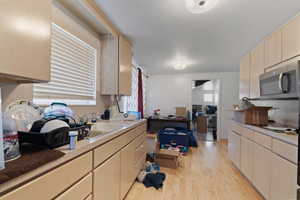 Kitchen with light hardwood / wood-style floors and sink