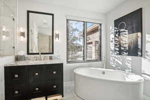 Bathroom featuring a washtub, vanity, and tile patterned flooring