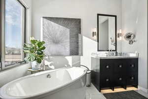 Bathroom with tile patterned floors, vanity, a healthy amount of sunlight, and a bath