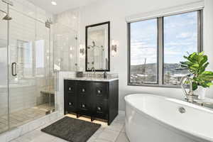 Bathroom featuring shower with separate bathtub, vanity, and tile patterned floors