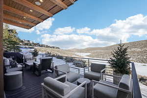 Snow covered deck featuring a mountain view and an outdoor hangout area