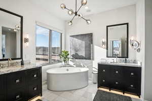 Bathroom featuring tile patterned floors, vanity, and a tub