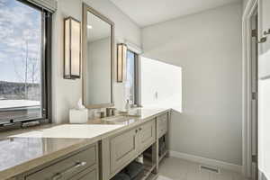 Bathroom with tile patterned floors, vanity, and a healthy amount of sunlight