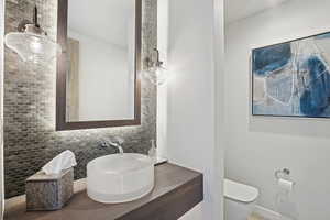 Bathroom with vanity, tasteful backsplash, and toilet