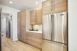 Kitchen featuring high end refrigerator and light hardwood / wood-style flooring