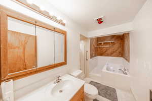 Full bathroom featuring vanity, tile patterned floors, separate shower and tub, toilet, and a textured ceiling