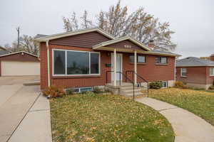 Bungalow-style house featuring a front yard, a garage, and an outdoor structure