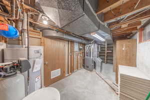 Basement featuring heating unit and water heater