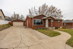 Bungalow featuring a garage and an outdoor structure