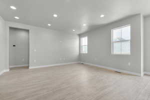 Spare room with light wood-type flooring and a textured ceiling