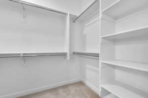 Spacious closet with light colored carpet