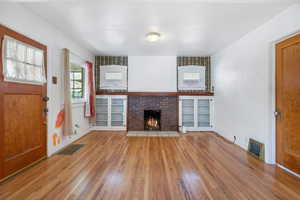 Unfurnished living room featuring a fireplace and light hardwood / wood-style flooring