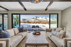 Living room with a mountain view, beamed ceiling, light parquet flooring, and plenty of natural light