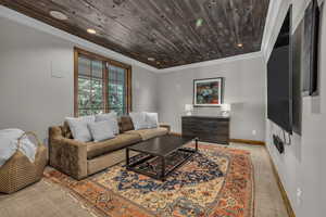 Living room featuring ornamental molding and wood ceiling