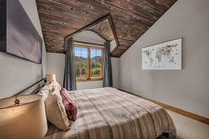 Carpeted bedroom featuring lofted ceiling, a mountain view, and wood ceiling