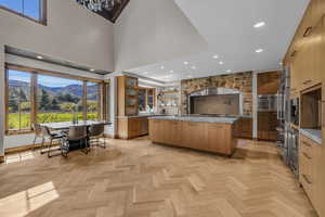 Kitchen featuring dishwasher, a center island, a high ceiling, a mountain view, and light parquet floors