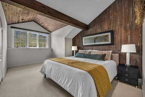 Bedroom with lofted ceiling with beams, light carpet, and wooden walls