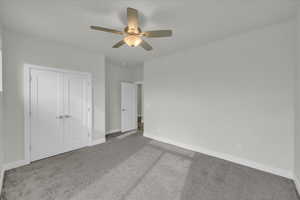 Unfurnished bedroom with light carpet, a closet, and ceiling fan