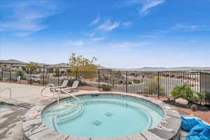 View of pool featuring a mountain view, a community hot tub, and a patio