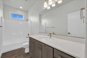 Full bathroom with shower / washtub combination, hardwood / wood-style floors, vanity, and toilet