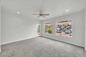 Carpeted spare room with ceiling fan