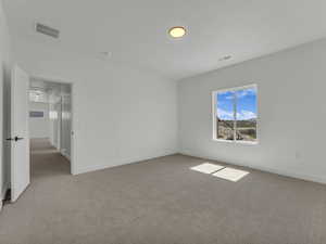 Bedroom featuring baseboards, visible vents, and light colored carpet