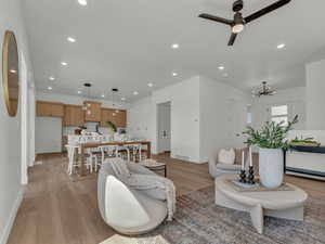 Living room featuring light wood-style flooring, baseboards, visible vents, recessed lighting, and a ceiling fan