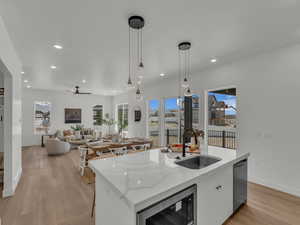 Kitchen featuring appliances with stainless steel finishes, a sink, a kitchen island with sink, and a healthy amount of sunlight
