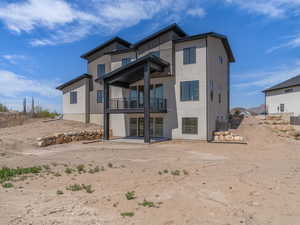Rear view of house with a patio area, a balcony, central air condition unit, and stucco siding