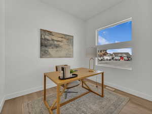 Office area featuring baseboards, wood finished floors, and visible vents
