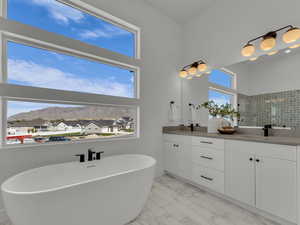 Primary Bathroom featuring a sink, marble finish floor, a soaking tub, double vanity, and a tile shower