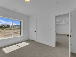 Unfurnished bedroom with visible vents, baseboards, and light carpet
