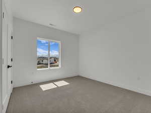 Spare room featuring baseboards, visible vents, and carpet