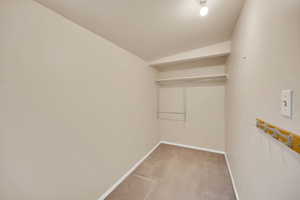 Walk in closet with light colored carpet