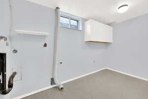 Washroom featuring electric dryer hookup, cabinets, and carpet floors