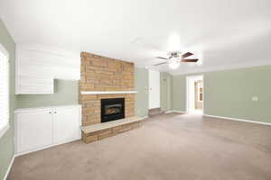 Unfurnished living room featuring ceiling fan, light carpet, and a wealth of natural light